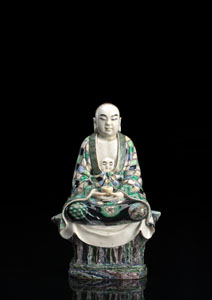 <b>A 'FAMILLE VERTE' BISCUIT PORCELAIN FIGURE OF SEATED LEHAN ON A ROCK PEDESTAL</b>