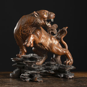 <b>A WOOD CARVING OF A TIGER ON ROCKS</b>