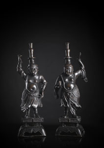 <b>Paar seltene und große Bronzeleuchter in Form von spiegelbildlich stehenden 'westlichen Barbaren' auf gestuften Ständern</b>
