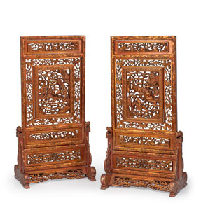 <b>TWO LARGE WOOD TABLE SCREENS, PARTLY CARVED IN OPENWORK WITH WARRIORS IN A MOUNTAIN LANDSCAPE AND VARIOUS LUCKY SYMBOLS, RED LACQUERED ON BOTH SIDES AND PARTIAL GILDING</b>