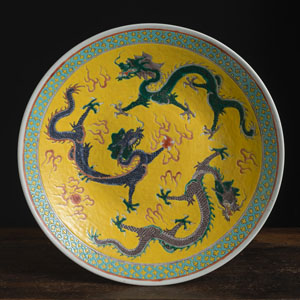 <b>Porzellanteller mit polychromem Dekor von drei Drachen auf gelbem Grund</b>