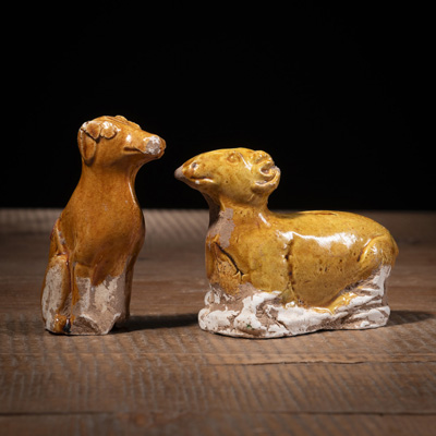<b>Zwei bernsteinfarben glasierte Keramikfiguren eines Hundes und eines Widders</b>