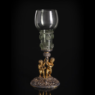 <b>A GERMAN GLASS RUMMER ON AN OPENWORK VERMEIL STAND HELD BY TWO PUTTI</b>