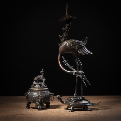 <b>A BRONZE CANDLESTICK IN THE SHAPE OF A CRANE STANDING ON A TURTLE AND A SMALL BRONZE TRIPOD INCENSE BURNER WITH COVER</b>