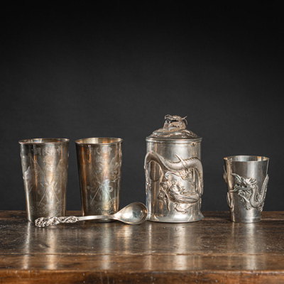 <b>Drei Becher, ein Humpen und ein kleiner Löffel aus Silber mit Drachendekor in Relief</b>