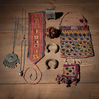 <b>Konvolut Kunstgewerbe:  drei Textilien teils mit Spiegelbesatz, zwei Armreifen, drei Ketten, ein kleiner Deckelkasten und eine Schnitzerei aus Holz</b>