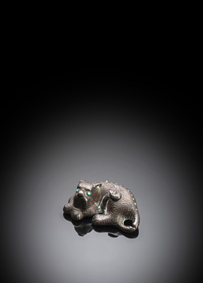 <b>Liegendes Fabeltier mit Silbereinlagen und Steinbesatz aus Bronze</b> <b>Liegendes Fabeltier mit Silbereinlagen und Steinbesatz aus Bronze</b>