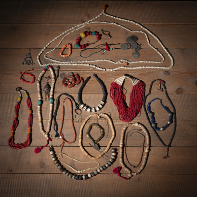 <b>A SMALL LACQUERED CHEST WITH FOURTEEN BONE, HORN, AND CORAL NECKLACES, THREE BRACELETS, AND VARIOUS PENDANTS AND FRAGMENTS</b>