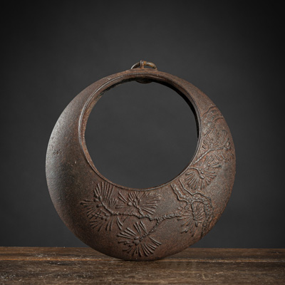 <b>A SMALL IRON IKEBANA HANGING VASE DECORATED WTH PINE SPRAYS</b>