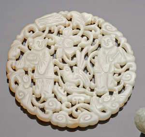 <b>Runde Jade-Plakette mit durchbrochen geschnitztem Dekor von 'He he Erxian' neben Fledermäusen, Lotus und Wolken</b>
