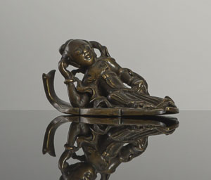 <b>Papiergewicht in Form einer liegenden Frau auf einem Blatt aus Bronze</b>