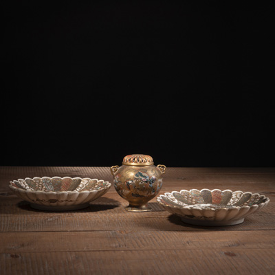 <b>TWO SATSUMA STONEWARE CHRYSANTHEMUM-SHAPED DISHES AND A SMALL KORO WITH FIGURAL SCENES IN RESERVES</b>