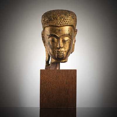 <b>A GILT- AND BLACK-LACQUERED STONE HEAD OF SHAKYAMUNI</b>