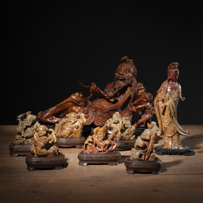 <b>Sieben Specksteinschnitzereien einer stehenden Guanyin und sechs Unsterblichen und Holzschnitzerei eines liegenden Fischers mit einem Knaben</b>