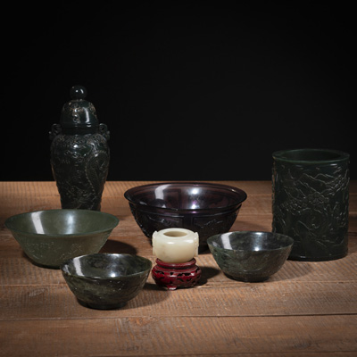 <b>Gruppe von sechs Objekten aus Jade, teils aus Spinatjade: Deckelvase, Pinselbecher, drei Schalen und kleiner Pinselwascher. Dazu eine auberginefarbene Glasschale mit Reliefdekor</b>