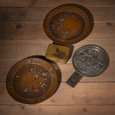 <b>Zwei flache Bronze-Teller und eine Deckeldose, verziert mit graviertem bzw. reliefiertem Blumen- und Vogeldekor, tauschiert in Gold, Silber und Kupfer-Legierungen, sowie ein Bronze-Handspiegel</b>