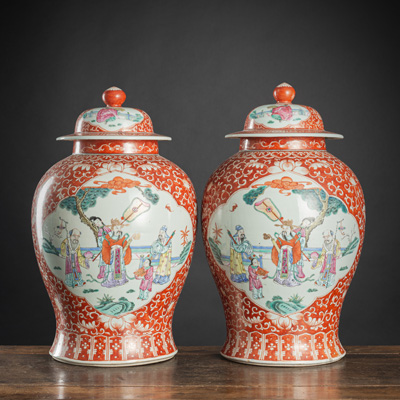 <b>Paar Deckelvasen aus Porzellan mit 'Famille rose'-Figurendekor in blütenförmigen Reserven auf eisenrotem Grund</b>