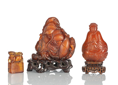<b>Siegel aus Bernstein, Gewicht mit Pfirsich und Chilong aus Bernstein und Buddha-Schnitzerei aus Bernstein auf Holzstand</b>