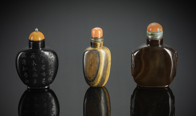 <b>Drei Snuffbottles aus Achat, mit Inschrift graviertes Jet (?) und Tigerauge, alle mit Stopper</b>