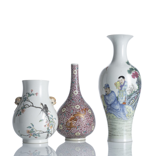 <b>Two 'Famille rose' vases and a bottle vase with dragon decoration between foliage and flowers on a purple background</b>