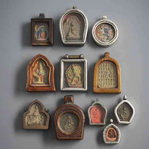 <b>Eleven gau, partly made of silver or wood, ten with tsha tsha or one with tsakli</b>