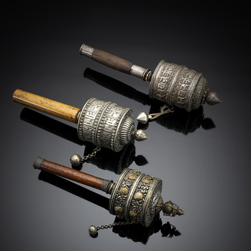 <b>A group of three prayer wheels, partly worked in silver with wooden handles, partly still filled with sutras</b>