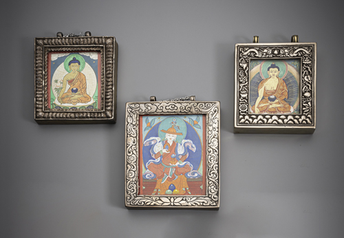 <b>Three gau, partly worked in silver and copper with tsaglis of Buddha Shakyamuni or a lama, partly filled with votive offerings</b>