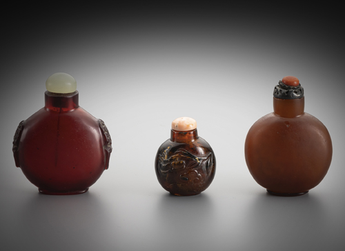 <b>An amber snuff bottle and two snuff bottle made of reddish amber-coloured glass</b> <b>An amber snuff bottle and two snuff bottle made of reddish amber-coloured glass</b>