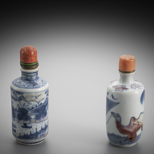 <b>Two cylindrical porcelain snuffbottles with copper-red and underglaze blue decoration of a camel leader in front of a gate or a seascape with architecture</b> <b>Two cylindrical porcelain snuffbottles with copper-red and underglaze blue decoration of a camel leader in front of a gate or a seascape with architecture</b>