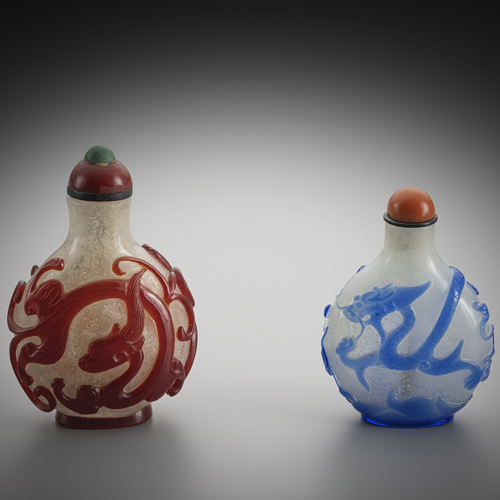 <b>Two snuff bottles made of snowflake glass with blue or red overlay of chllong and dragon</b> <b>Two snuff bottles made of snowflake glass with blue or red overlay of chllong and dragon</b>
