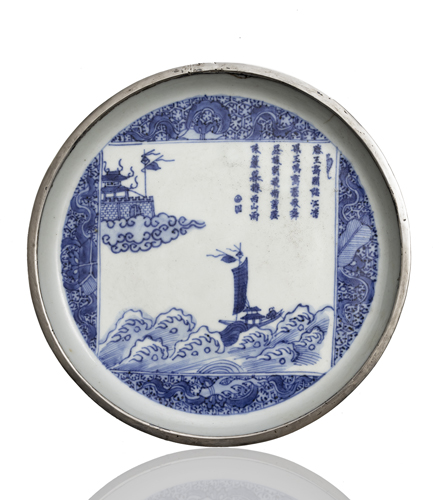 <b>AN UNDERGLAZE BLUE FLAT PLATE WITH SILVER FITTING ON THE RIM AND DEPICTING A PAVILION AND A BOAT ON THE WAVES AND A POEM</b>