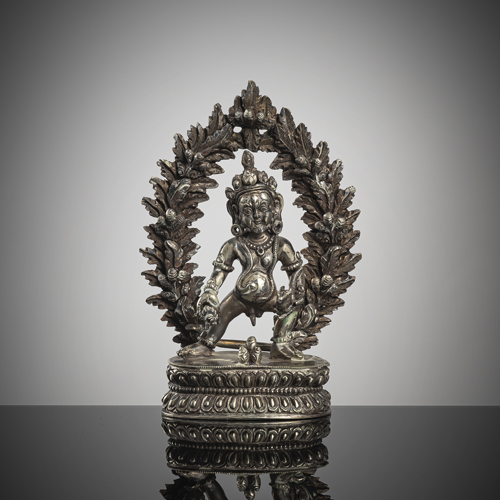 <b>A fine filigree silver figure of Vaishravana standing on a lotus in front of a mandorla</b>