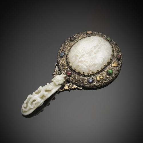 <b>A silver hand mirror with fine relief decoration, inlaid jade carvings and gemstones</b>