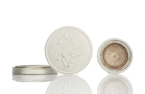 <b>A biscuit porcelain inkwell with peach branch in relief and an ink rubbing stone</b>