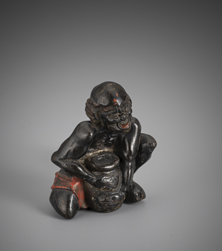 <b>A netsuke of a South Sea Islander made of wood, holding a basket</b>