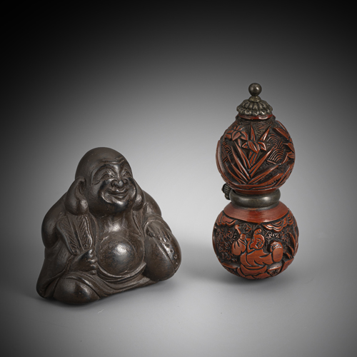 <b>Netsuke of a calabash in carved red lacquer and netsuke of the Hotei in black-brown wood</b>