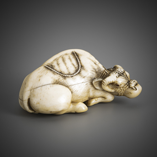 <b>A carved ivory netsuke of a reclining water buffalo</b>