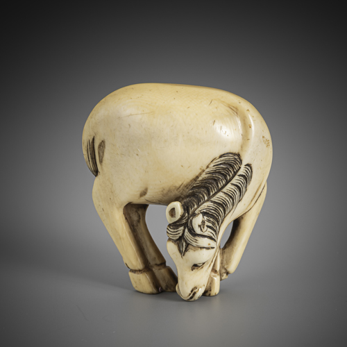 <b>A well carved ivory netsuke of a standing grazing horse</b>