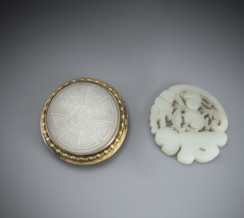 <b>Two finely carved jade discs, one mounted in a lid, the second as a pendant with a stylised dragon and peach branch</b>
