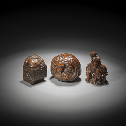 <b>A netsuke of an Oni in a box,a netsuke of Daikoku in a sack and arider with servant, all carved in medium brown wood</b>