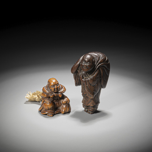 <b>A middle brown carved wood netsuke of a seated man with a cat and carved wood netsuke of a standing man with a large sack</b>