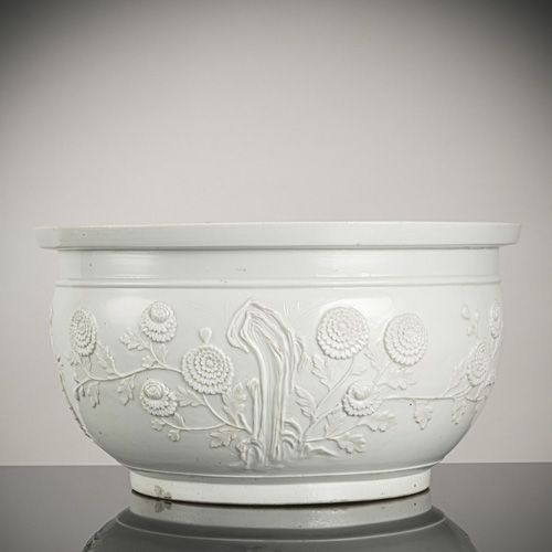 <b>A large 'blanc de chine' porcelain jardinière with relief decoration of chrysanthemums, bamboo, plum branches and rocks</b>