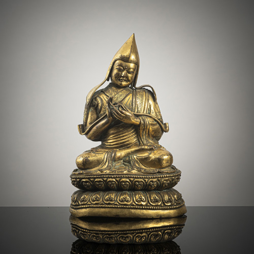 <b>A GILT-COPPER EMBOSSED FIGURE OF A LAMA</b>