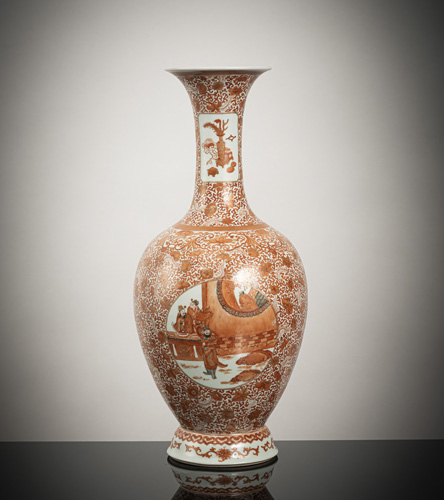 <b>An iron-red porcelain baluster vase depicting literary scenes within oval reserves on a floral scroll ground</b> <b>An iron-red porcelain baluster vase depicting literary scenes within oval reserves on a floral scroll ground</b>