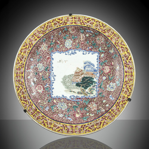 <b>A 'famille rose' porcelain charger with a square image of a building on a riverbank on a lotus and peonies ground</b> <b>A 'famille rose' porcelain charger with a square image of a building on a riverbank on a lotus and peonies ground</b>