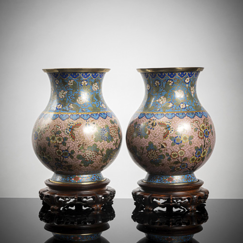 <b>A pir of cloisonné vases decorated with butterflies and flowers on a pink-coloured ground, partially fire-gilt, wooden stands</b>