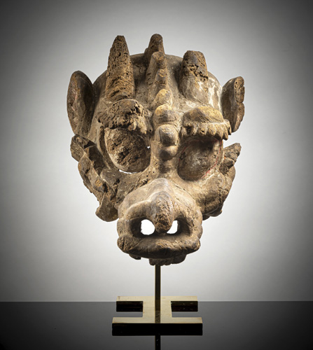 <b>Part of a mask in the shape of a wooden dragon's head on a metal stand</b>