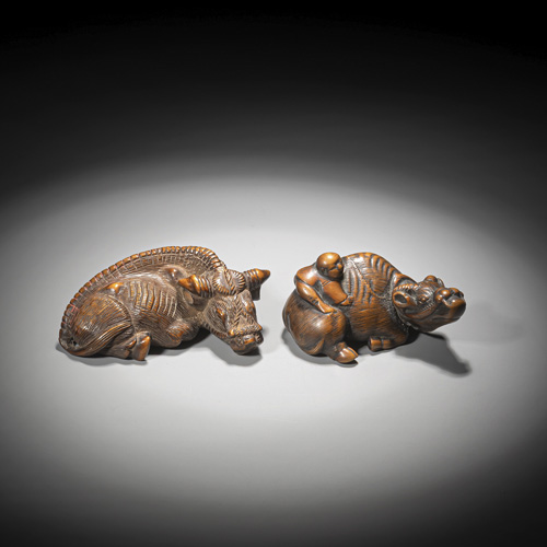 <b>Two reclining oxen made of medium brown wood, one with a herdboy</b>