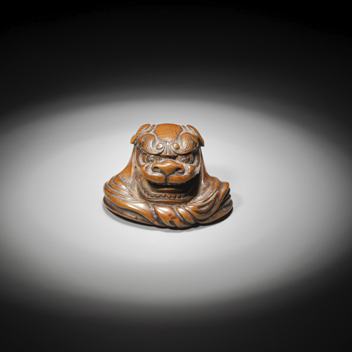 <b>A fine netsuke of a seated boy with a large shishimai mask (lion mask) carved of medium brown wood</b>