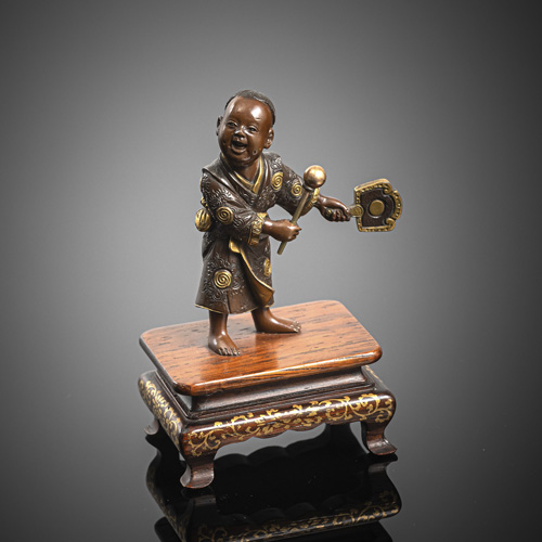 <b>A small Miyao bronze of a boy with rackets on a wooden stand</b>